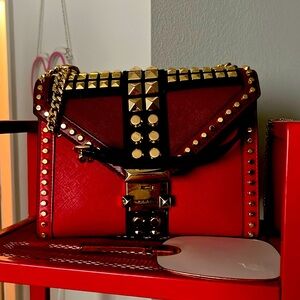 Two tone red leather with gold studs and chain strap.